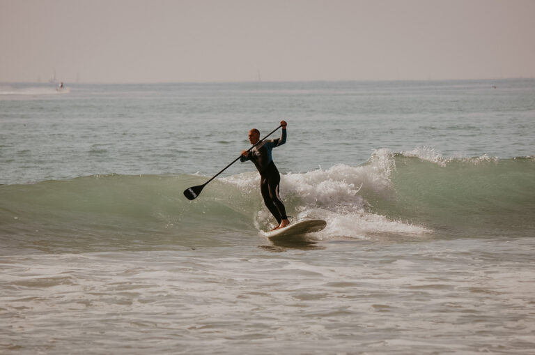 Surfer auf SUP surft eine Welle in einer SUP Privatstunde auf Sylt